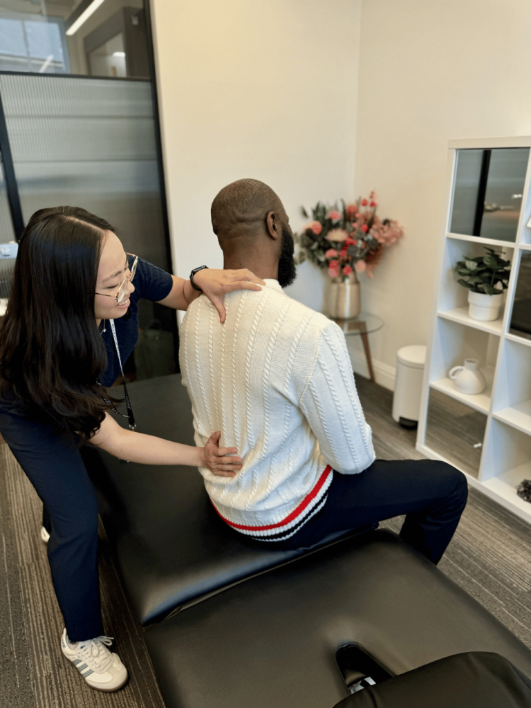 A physio giving a Physiotherapy Bromley treatment to a patient with back pain.